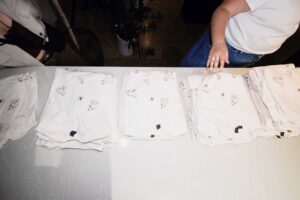 Pantalons blancs pliés, prêts à être distribués ou vendus dans un environnement de travail.
