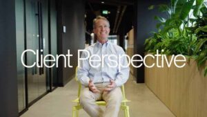 Homme souriant assis dans un bureau moderne, perspective client.