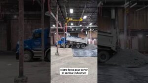 Camion de chantier déchargeant des matériaux dans une usine A+.