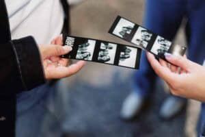Photo de personnes manipulant une bande de négatifs ou de photos.