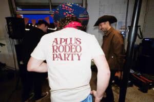 Personne portant un t-shirt "A Plus Rodeo Party" lors d'une fête country.