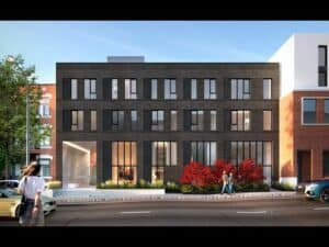 Facade moderne en construction avec grandes fenêtres et espaces verts.