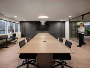 Salle de réunion professionnelle avec grande table et sièges modernes.