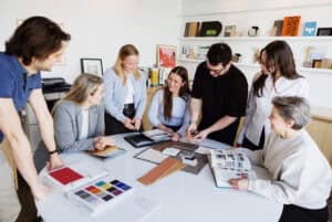 Groupe de professionnels collaborant sur un projet de design intérieur dans un bureau moderne.