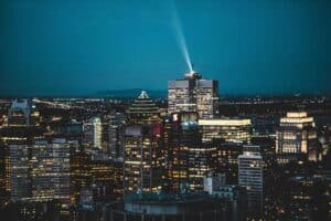 Vue nocturne de Montréal avec gratte-ciel illuminés et ciel étoilé.