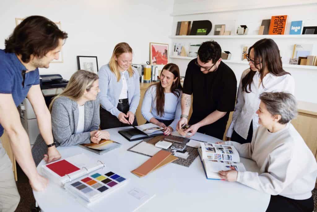 Groupe de professionnels en design intérieur en réunion de travail.
