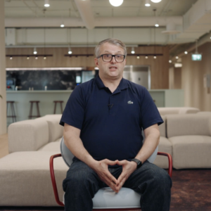 Homme assis dans un espace de coworking moderne et lumineux.