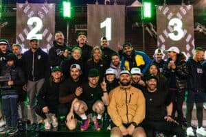 Groupe de sportifs heureux sur podium avec trophée et médailles.