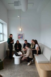 Groupe de collègues en discussion dans un espace de travail lumineux.