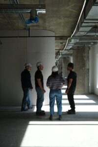 Groupe de quatre personnes en discussion sur un chantier de construction.