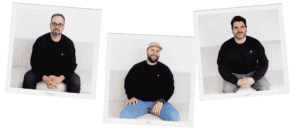 Trois hommes assis, souriants, dans un environnement professionnel.