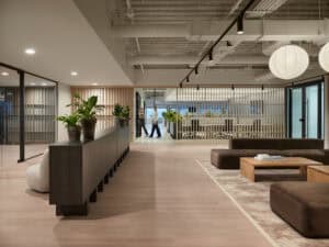 Espace de coworking lumineux avec mobilier contemporain et plantes d'intérieur.