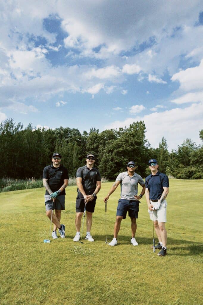Groupe d'amis jouant au golf en plein air sous un ciel bleu.