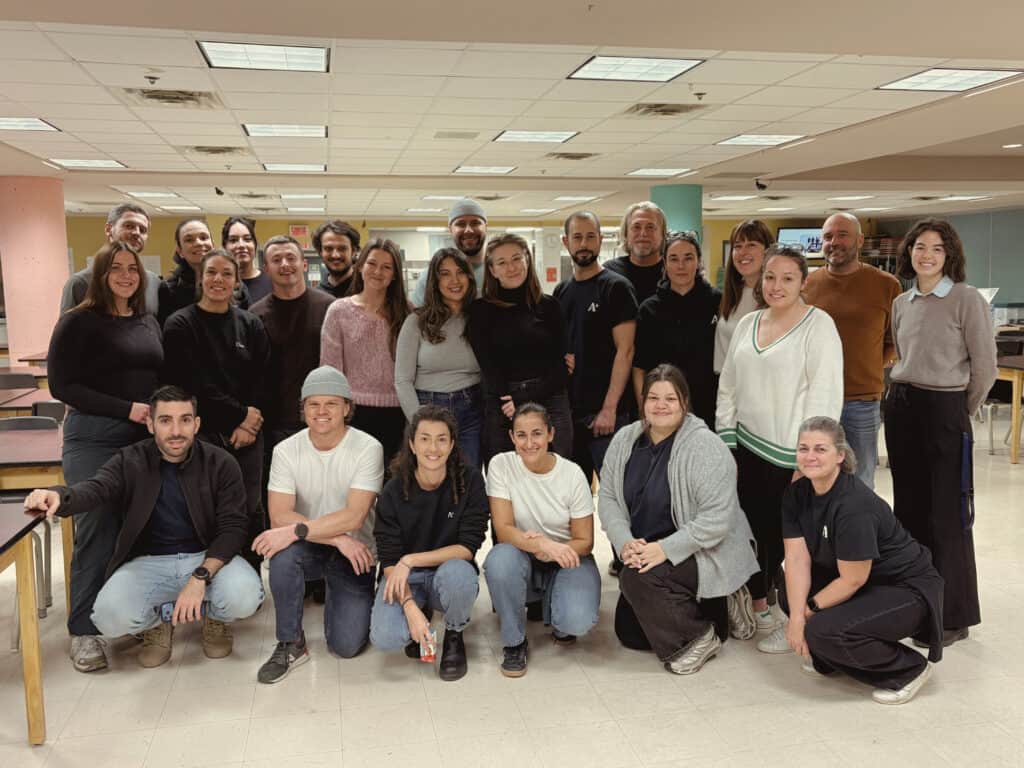 Groupe de collaborateurs souriants dans un environnement de bureau moderne.