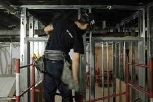 Technicien en installation électrique dans un bâtiment en construction.